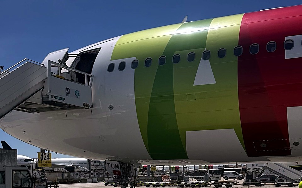 Avião da TAP estacionado junto à ponte de embarque