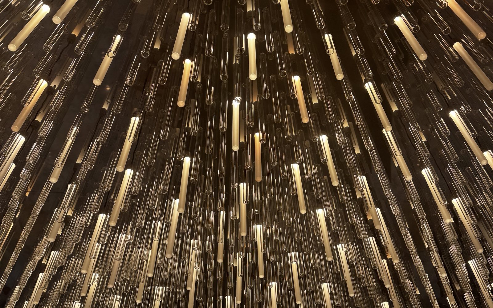 Instalação de tubos de vidro iluminados no interior do Rosewood São Paulo